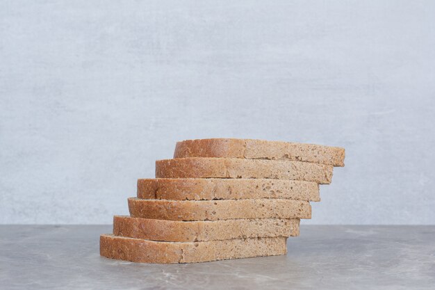 Slices of brown bread on marble surface