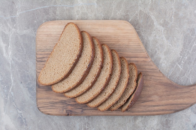 Free photo slices of brown bread on marble surface