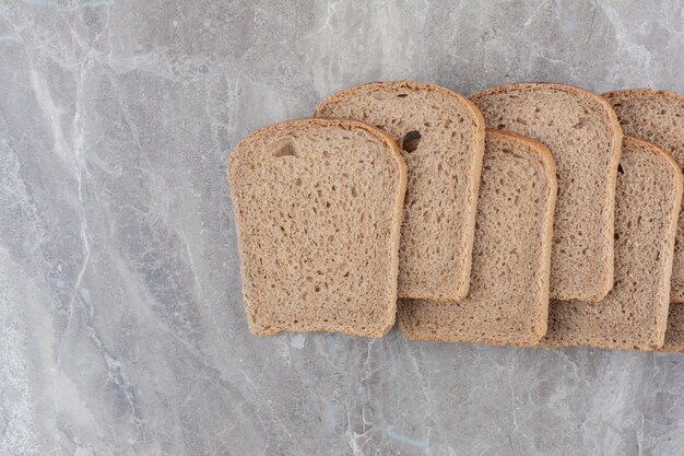 Slices of brown bread on marble surface