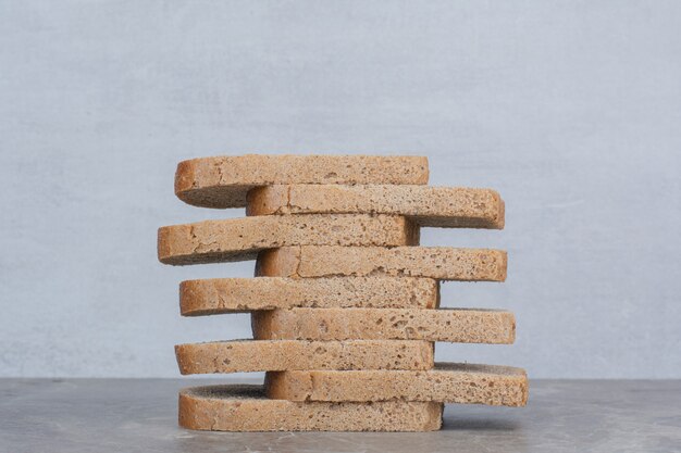 Slices of brown bread on marble surface