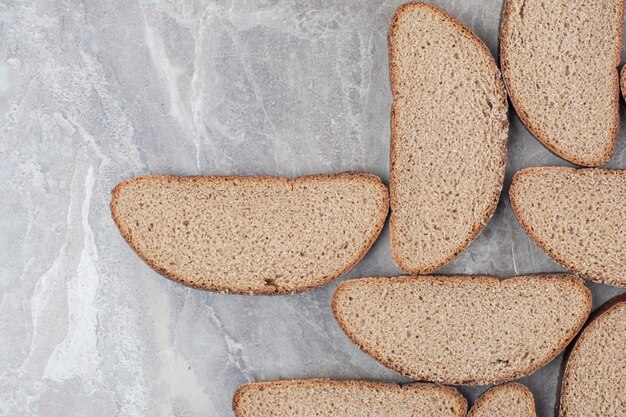 Slices of brown bread on marble surface