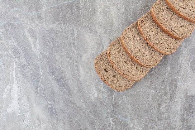 Slices of brown bread on marble surface