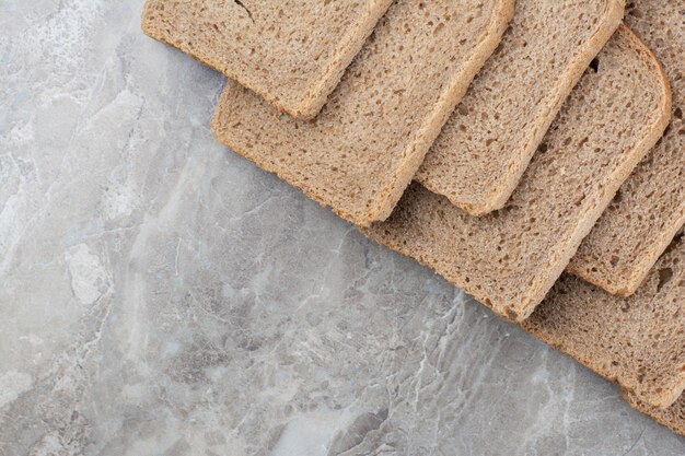 Slices of brown bread on marble surface