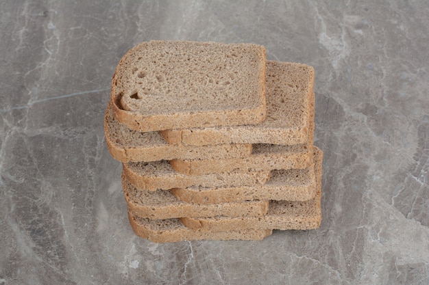 Slices of brown bread on marble surface