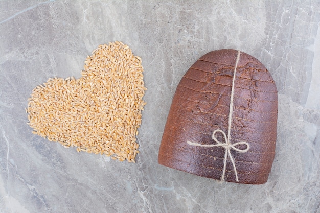 Free photo slices of brown bread with oat grains on marble surface