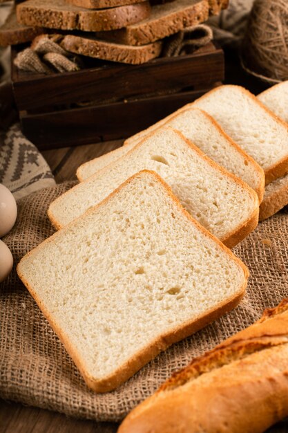 Slices of dark and white bread in box and on tablecloth