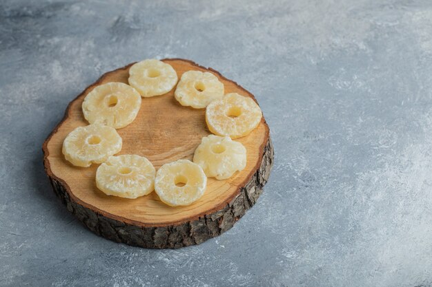 Slices of dried pineapple on a wooden board. 