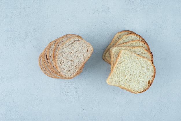 Free photo slices of fresh bread on stone surface