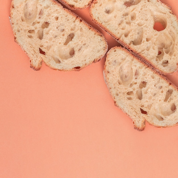 Slices of fresh bread with copy space on peach backdrop