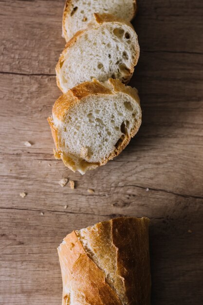 Slices of fresh breads on wooden background