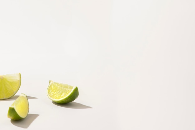 Slices of fresh green lime on white