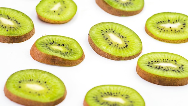 Slices of fresh kiwi fruits on white surface