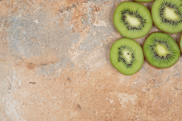 Free photo slices of fresh kiwi on marble bakground.