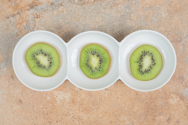 Slices of fresh kiwi on white plate. 