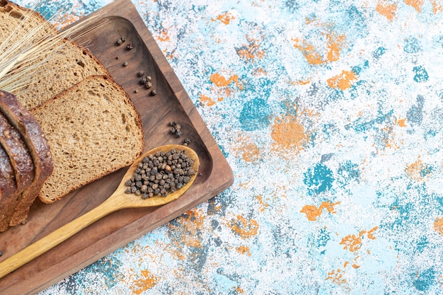 Free photo slices of fresh loaf of bread on wooden board.