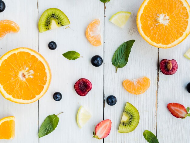 Slices of fresh tropical bright fruit on wooden background