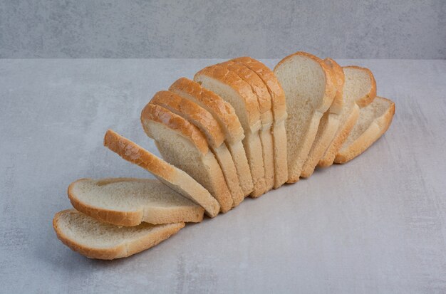 Slices of fresh white bread on marble background.