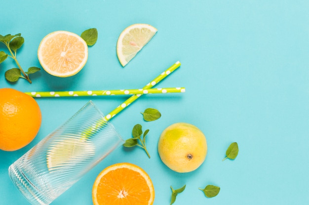 Free photo slices of fruits between herbs and glass