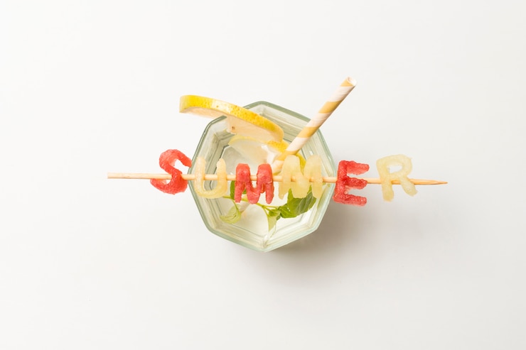 Free Photo slices of fruits near ice and summer title on glass