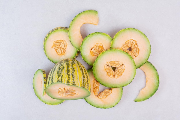 Slices of green melon on white table.