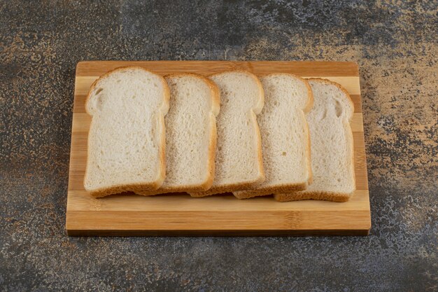 Slices of homemade bread on wooden board.