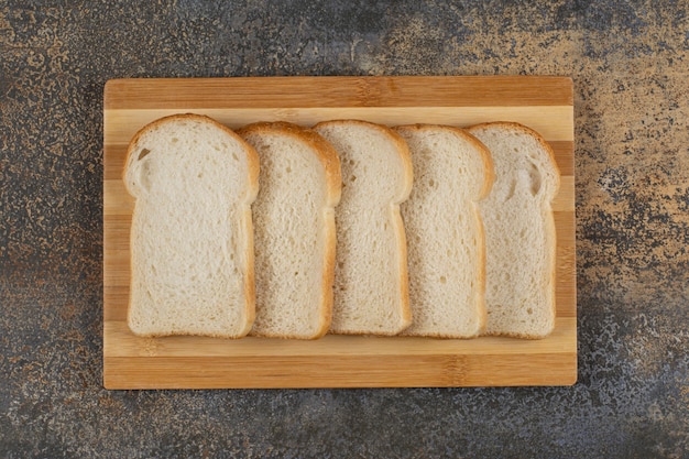 Free photo slices of homemade bread on wooden board.