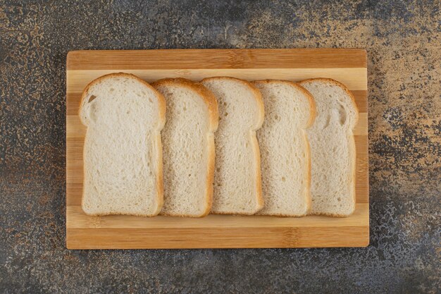 Slices of homemade bread on wooden board.