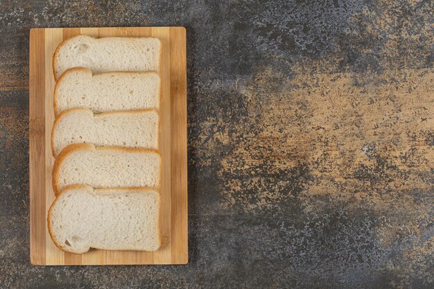 Slices of homemade bread on wooden board.