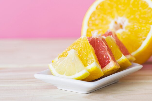 Slices of juicy citrus fruits on plate