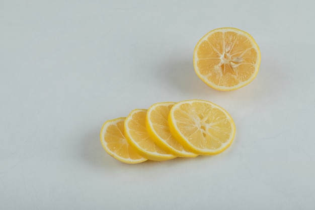 Free photo slices of juicy lemon on a white surface.