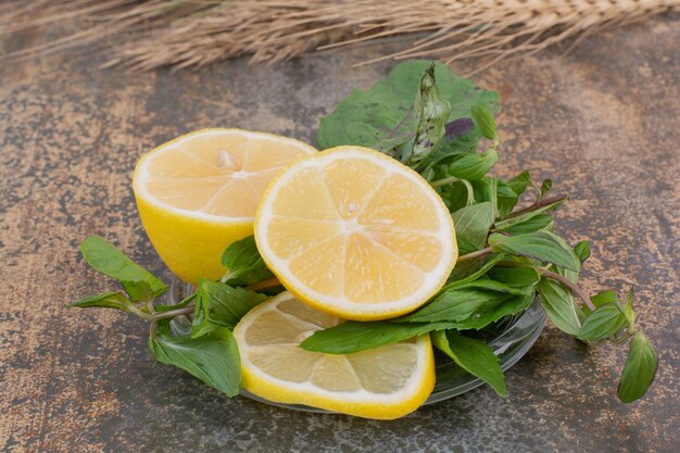 Slices of lemon with mint on stone surface
