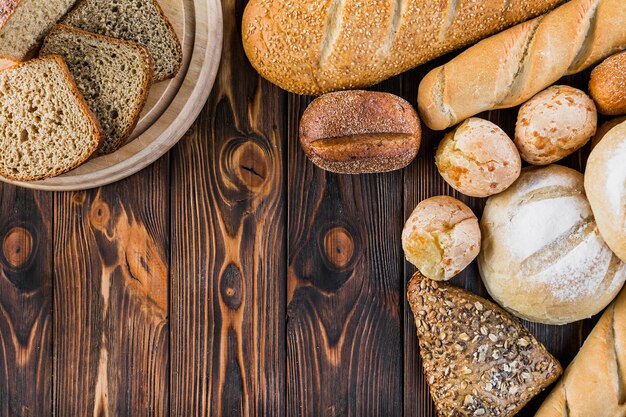 Slices and loves of freshly bread on wooden table