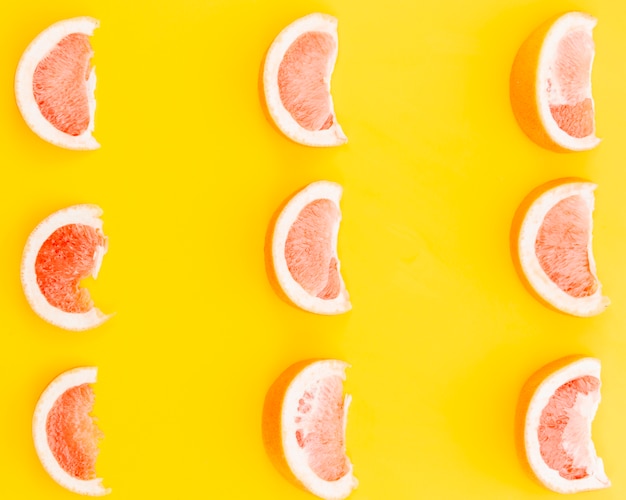 Бесплатное фото Ломтики грейпфрута на желтом фоне