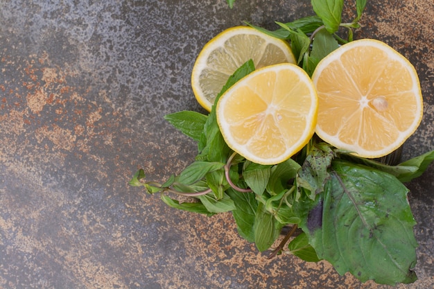 Бесплатное фото Дольки лимона с мятой на мраморной поверхности