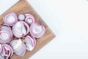 Free photo slices of purple onion on wooden board.