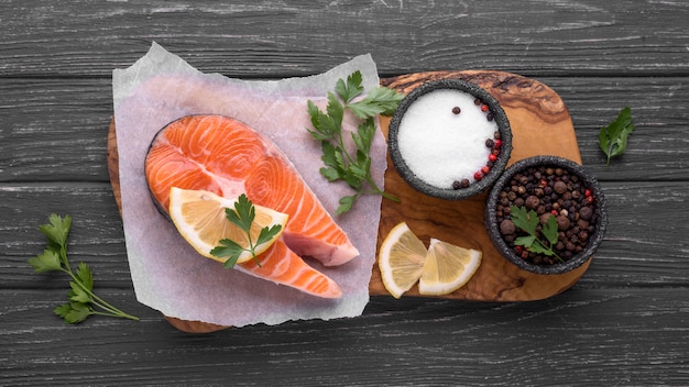 Slices of raw red salmon on wooden board