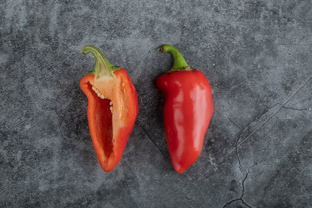 Slices of red pepper on a gray background.