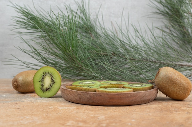 Foto gratuita fette di kiwi maturo sul piatto di legno.