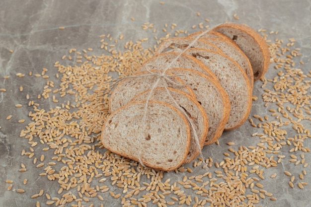大理石の表面に穀物が付いているライ麦パンのスライス。高品質の写真