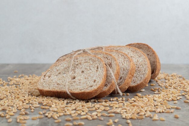 Slices of rye bread with grains on marble table. High quality photo