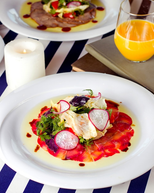 Slices of smoked salmon served with radishes lettuce and greens