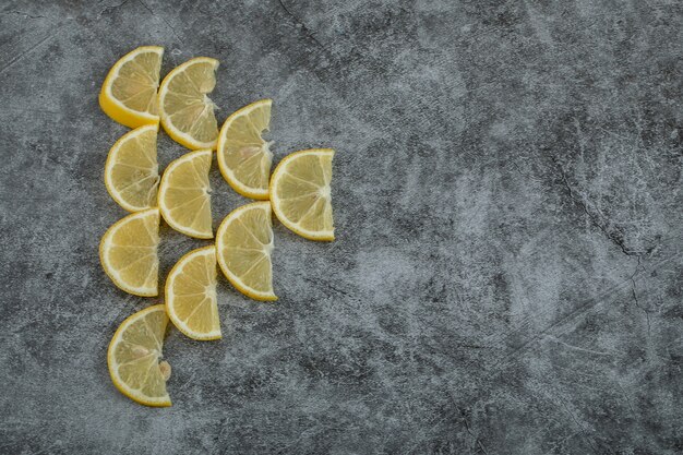 Slices of sour lemon on a gray background.