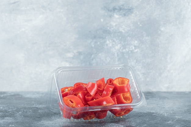 Slices of sweet red peppers on plastic plate.