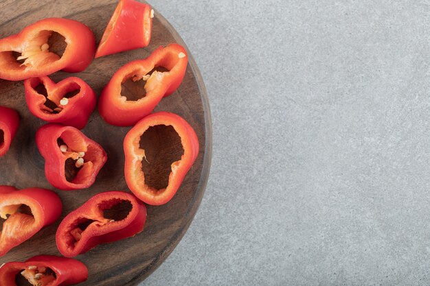 Free photo slices of sweet red peppers on a wooden board.