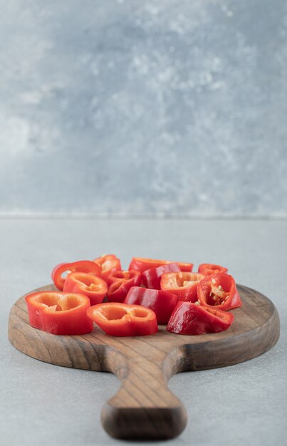 Slices of sweet red peppers on a wooden board. 