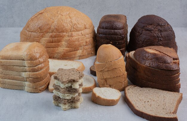 Slices of various of fresh breads on white background. 