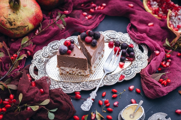 Slices of vegan cake on a metal plate with berries on top