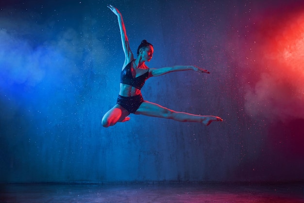 Slim ballerina jumping under rain