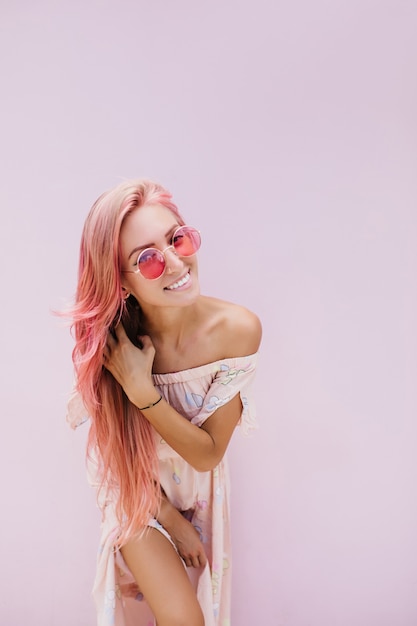 Slim beautiful woman with long pink hair with gently smile.