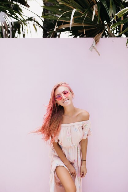 優しい笑顔で長いピンクの髪を持つスリムな美しい女性。